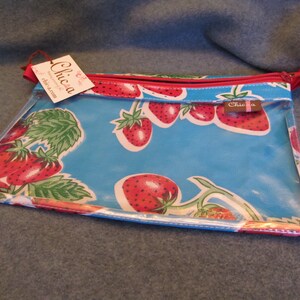 Puede incluir: Una bolsa de pl&aacute;stico transparente con cremallera, con fondo azul y cremallera roja. La bolsa tiene un estampado de fresas y el texto "Chica" en la parte delantera.