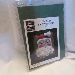 May include: A white card with a green background and a picture of a Santa Claus face with a white beard. The card says "Itty Bitty Santa's Beard 1999" and "Twisted Threads".