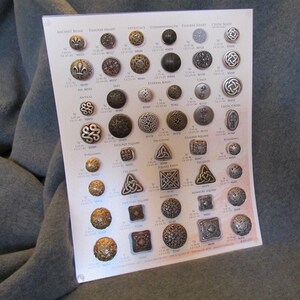 May include: A white card with a grid of metal buttons in various designs and finishes. The buttons are arranged in rows and columns, with each button labeled with a name and number. The card is a sample card for a variety of metal buttons.