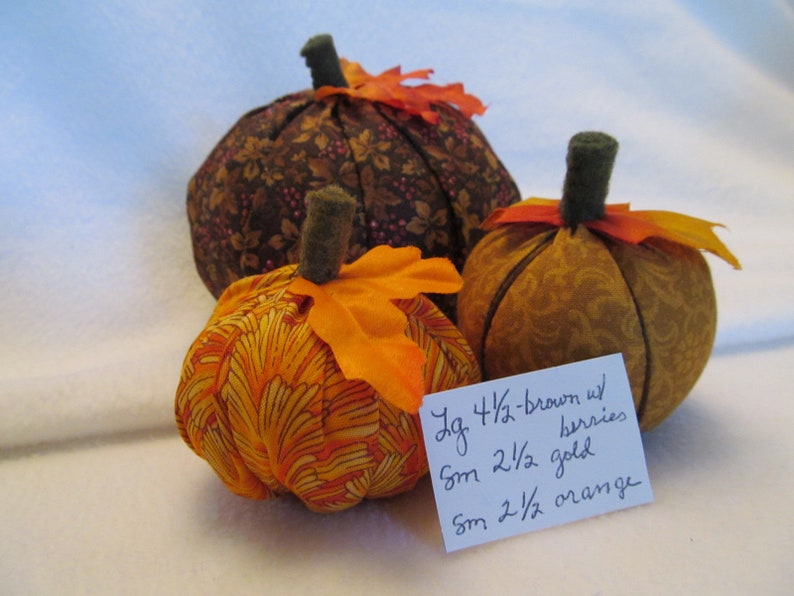 A Set of Three Fabric Pumpkins for the Autumn One Bright Orange Pumpkin One Gold on Gold Pumpkin One Large Brown with Berries Pumpkin