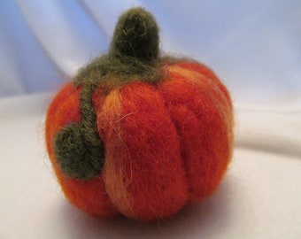 May include: A small, hand-felted pumpkin with a green stem and orange and cream stripes.