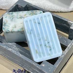 May include: Two bars of handmade soap in a light blue color with green and white flecks. The soap is in a wooden crate with a distressed gray finish.