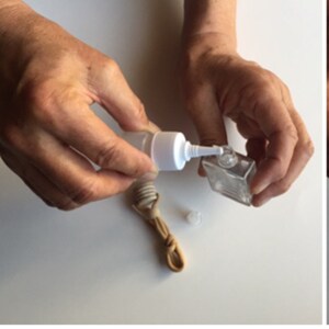 May include: A three-panel image sequence shows the assembly of a small, clear glass bottle with a wooden top. The bottle is filled with a liquid, and a wooden diffuser is inserted. The first panel shows a box with a cotton-like material and a bottle.
