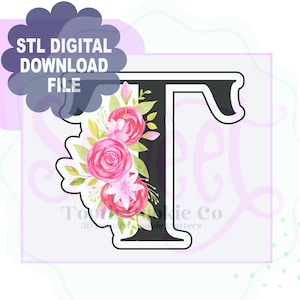 May include: A black letter "T" with a floral design. The flowers are pink and red roses with green leaves. The text "STL DIGITAL DOWNLOAD FILE" is in a cloud-shaped bubble.