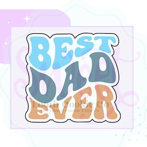 May include: A cookie cutter with the words "BEST DAD EVER" in a retro font. The text is in shades of blue, teal, and orange, outlined in black. The words are on a light purple background.