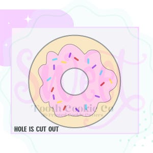 May include: A pink frosted donut cookie cutter with sprinkles. The hole in the center is cut out. "HOLE IS CUT OUT" is written below the donut.