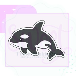 May include: A 3D printed cookie cutter shaped like an orca whale. The design features the distinct black and white markings of an orca, including the dorsal fin, eye patch, and tail fluke, with a white outline border for cutting dough.