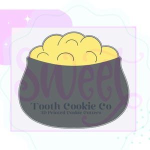 May include: A black cookie cutter shaped like a cauldron filled with gold coins. The cutter is labeled "Tooth Cookie Co. 3D Printed Cookie Cutters".