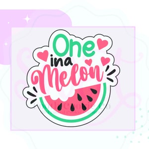 May include: A green and pink watermelon-shaped cookie cutter with the text "One in a Melon!" in black and white lettering. There are also several small pink hearts around the text.