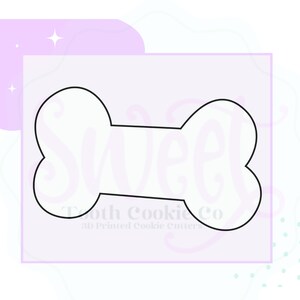 May include: A white outline of a dog bone cookie cutter. The cookie cutter is on a light purple background with white polka dots.