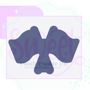 May include: A blue cookie cutter in the shape of two flags crossed over each other. The cookie cutter is for making cookies in the shape of crossed flags. The text "Tooth Cookie Co. 3D Printed Cookie Cutters" is visible at the bottom of the image.
