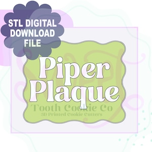 Pode incluir: Um arquivo de download digital com o texto "STL DIGITAL DOWNLOAD FILE" em um gráfico em forma de nuvem azul escuro. A imagem apresenta uma placa verde clara com o nome "Piper Plaque" em letras brancas com uma borda rosa. O texto "Tooth Cookie Co 3D Printed Cookie Cutters" também está presente.