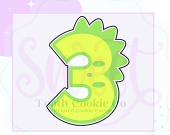 May include: Green cookie cutter shaped like the number 3 with a jagged edge. The number 3 has a small hole in the center and two small holes on the right side.