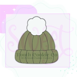May include: A cookie cutter in the shape of a winter hat with a pom-pom. The hat is olive green with vertical lines and a white pom-pom. The text "Tooth Cookie Co" and "3D Printed Cookie Cutters" is at the bottom.