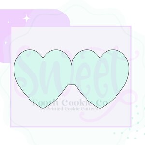 May include: A cookie cutter in the shape of two connected hearts. The cutter is outlined in black and filled with a light blue color. The text "Sweet" is written in a cursive font over the cutter. The text "Tooth Cookie Co. 3D Printed Cookie Cutters" is written below the cutter.