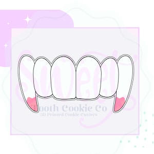 May include: A white cookie cutter in the shape of vampire teeth with pink accents on the fangs. The text "Tooth Cookie Co" and "3D Printed Cookie Cutters" is printed on the bottom of the image.