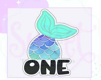 May include: A mermaid tail cookie cutter with a teal and blue watercolor design. The tail is connected to the word "ONE" in a bold, black font. The design is set against a light purple background with decorative elements.