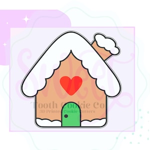 May include: A gingerbread house cookie cutter with a white roof, a green door, and a red heart on the front. The cutter is made of metal and has a smooth finish.