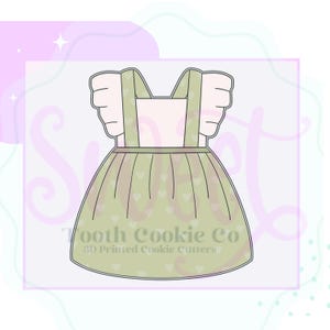 May include: A green cookie cutter in the shape of a dress with a white bodice and straps. The skirt has a heart pattern. The cookie cutter is labeled "Tooth Cookie Co. 3D Printed Cookie Cutters".