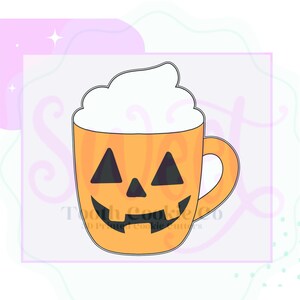 Puede incluir: Cortador de galletas con forma de taza de calabaza naranja con una cara sonriente de jack-o'-lantern y cobertura de crema batida. La taza tiene un asa y está diseñada para hornear con temática de Halloween. El texto "Tooth Cookie Co" es visible.