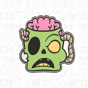 May include: A green zombie head cookie cutter with a pink brain, a black eye, and a yellow eye. The cookie cutter has a handle and a jagged edge, perfect for Halloween treats.