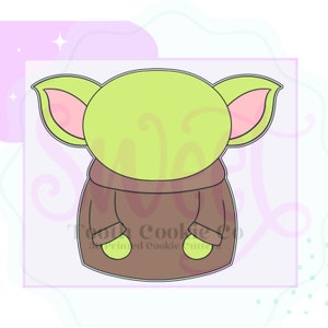 May include: A green and brown cookie cutter in the shape of a character from the Star Wars franchise. The character has large ears and is wearing a brown robe.