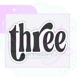 May include: A black cookie cutter in the shape of the word "three" with a stylized font.