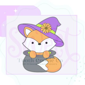 May include: A purple and green witch hat with a yellow flower on top. A fox wearing the hat is peeking out of a gray cauldron. The fox is orange with a white face and a white tail.