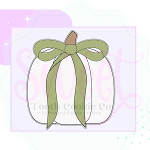 May include: A white pumpkin cookie cutter with a green bow. The pumpkin has a brown stem and is outlined in black. The text "Tooth Cookie Co" is printed on the bottom of the image.