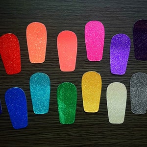 Peut inclure: Assortiment de 15 couleurs de paillettes en forme d'ovale. Les couleurs incluent le rouge, l'orange, le rose, le violet, le bleu, le vert, le jaune, le blanc, le noir et le gris.