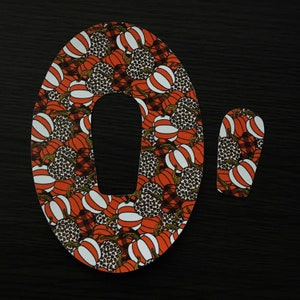 May include: A large orange and white patterned fabric letter O with a smaller orange and white patterned fabric letter O next to it.