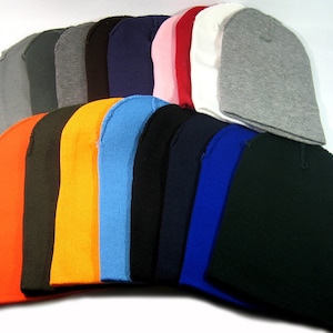 May include: A collection of 18 plain knit beanies in various colors, including orange, black, blue, red, white, and gray.
