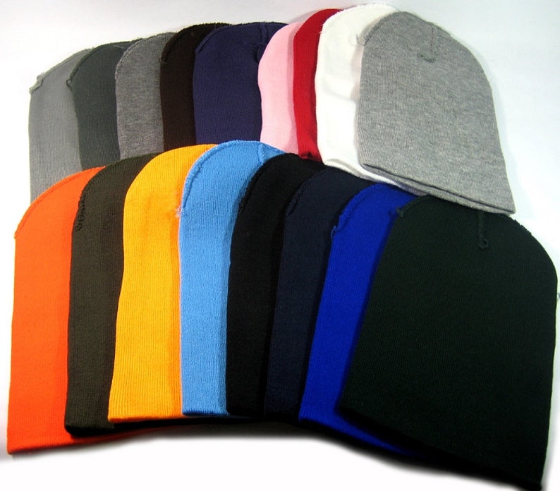 May include: A collection of 18 plain knit beanies in various colors, including orange, black, blue, red, white, and gray.