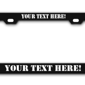May include: Black metal license plate frame with white text that says "YOUR TEXT HERE!" on the top and bottom.