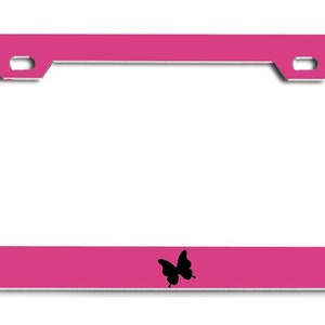 May include: A pink metal license plate frame with a black butterfly silhouette in the center.
