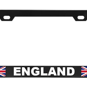 May include: Black license plate frame with the word "ENGLAND" in white block letters. The frame features the Union Jack flag on each side of the word.