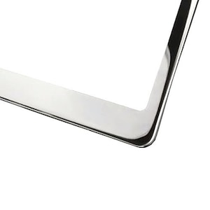 May include: A silver metal picture frame with a smooth, polished finish. The frame has a simple, rectangular design.
