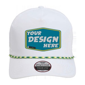 Op de afbeelding: Witte baseballcap met een turquoise en gele patch met de tekst "YOUR DESIGN HERE". De cap heeft een groen en geel touwdetail langs de rand en een "TRUE FIT" label.
