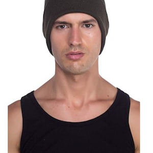 May include: A dark green beanie hat with a ribbed texture. The hat is made of a soft, comfortable material and is perfect for keeping your head warm in the winter.