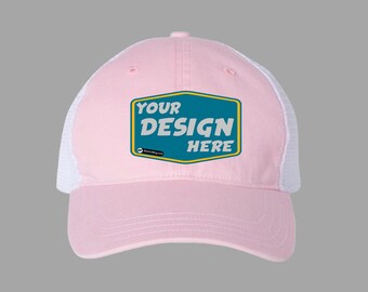 May include: Pink and white trucker hat with a blue and yellow patch that says "YOUR DESIGN HERE".