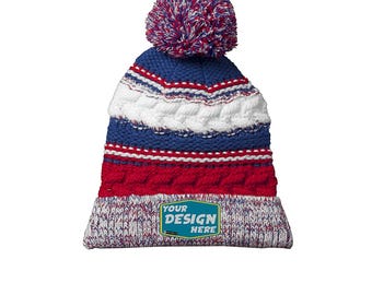 Könnte beinhalten: Eine blaue, rote und weiße Strickmütze mit einem Bommel oben. Die Mütze hat ein weißes, rotes und blaues Streifenmuster. Die Mütze hat einen kleinen rechteckigen Aufnäher auf der Vorderseite, auf dem "YOUR DESIGN HERE" steht.