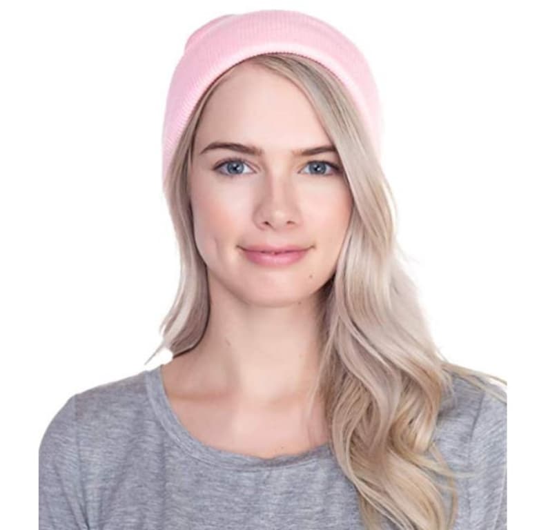 May include: A pink knit beanie hat. The hat is made of soft, warm material and is perfect for keeping your head and ears warm in the winter.