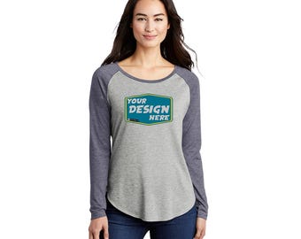 Könnte beinhalten: Ein langärmliges T-Shirt in Grau meliert und Marineblau mit einem abgerundeten Saum. Das Shirt hat einen Raglan-Schnitt und zeigt eine blaue und grüne rechteckige Grafik mit dem Text "YOUR DESIGN HERE".