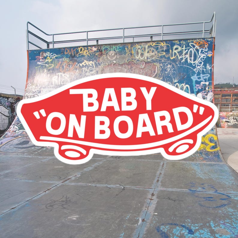 Op de afbeelding: Een rode en witte sticker met de tekst "BABY "ON BOARD" op een skatebaan. De baan is gemaakt van beton en heeft graffiti.