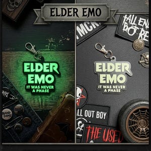 May include: A glow-in-the-dark keyring featuring the text "ELDER EMO" and "IT WAS NEVER A PHASE" in a bold font. The keyring is shown in two states: glowing green in a dark setting and as a solid black object in a well-lit environment.