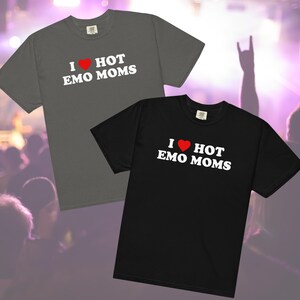 Op de afbeelding: Twee T-shirts met de tekst "I love hot emo moms" erop gedrukt. De shirts zijn grijs en zwart met een rood hart.