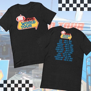 Puede incluir: Una camiseta negra con un gráfico amarillo y rojo de un cartel que dice "HHN Icons World Tour". La parte posterior de la camiseta enumera los nombres de las diferentes casas encantadas que se han presentado en Halloween Horror Nights en Universal Studios a lo largo de los años.