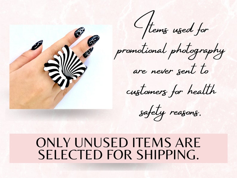 Peut inclure: Une bague noire et blanche avec un motif en spirale. La bague est port&eacute;e sur une main avec un vernis &agrave; ongles noir. Le texte "Items used for promotional photography are never sent to customers for health safety reasons. ONLY UNUSED ITEMS ARE SELECTED FOR SHIPPING." est affich&eacute; sous l'image.