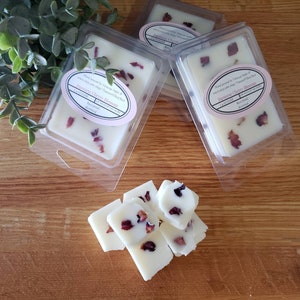 May include: Four wax melts in clear plastic containers with white wax and red flower petals. The wax melts are labeled "Japanese Cherry Blossom" and "Orange Cherry Blossom".