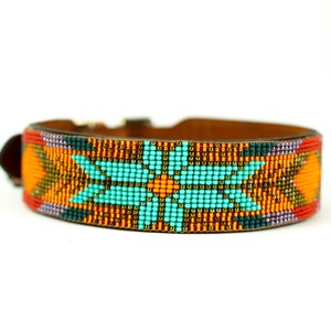 May include: A brown leather dog collar with a colorful beaded design. The design features a turquoise flower with orange and yellow accents.